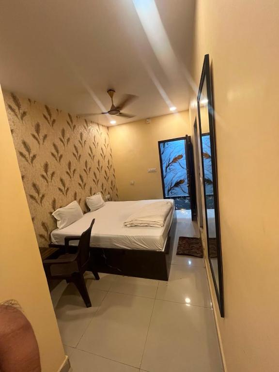 a small bedroom with a bed and a chair at Hotel Royal Palace in Kolkata