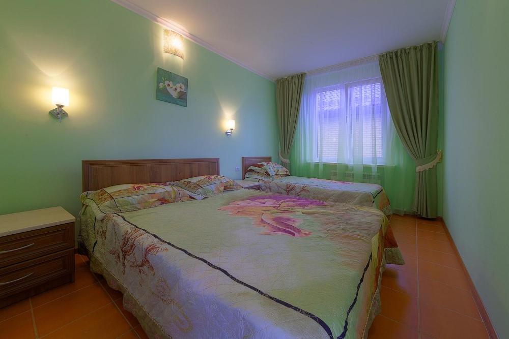 a bedroom with a large bed with a snake on it at Орхидея, семейный гостевой дом in Vityazevo
