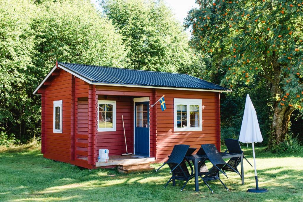 a small red cabin with a table and chairs at Alevi Camping in Stöllet