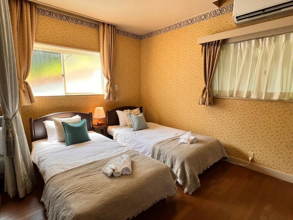 a bedroom with two beds with towels on them at 伊豆ビーチクラブ in Shimoda