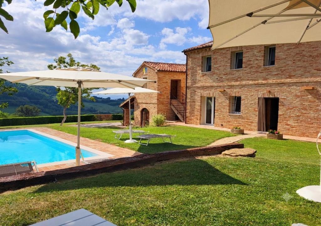 an external view of a villa with a swimming pool at B&B Le Quattro Civette in Montefelcino