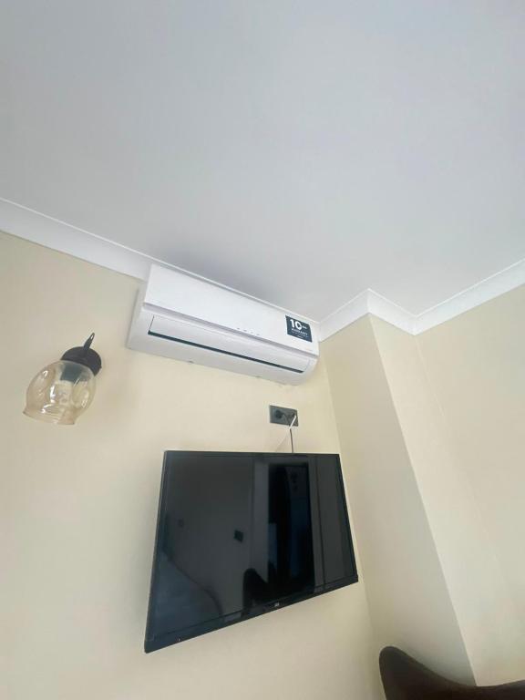 a living room with a tv and a ceiling at Mira Residence in Bostancı