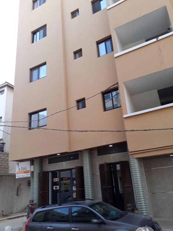 a building with a car parked in front of it at Américain studio ngor almadies in Dakar