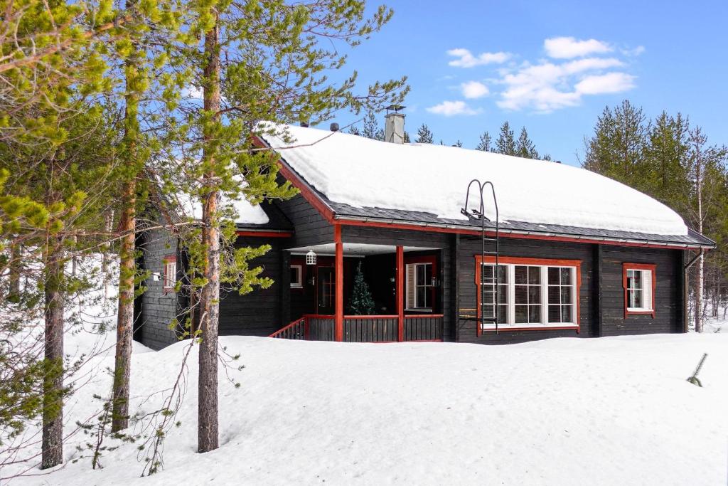 a log cabin in the snow with trees at Orrenkolo, Lapland in Luosto