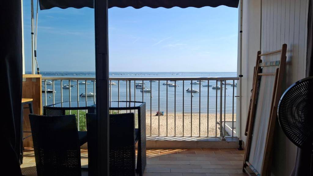 a balcony with a view of the beach and boats at Duplex vue mer et accès plage in Arcachon