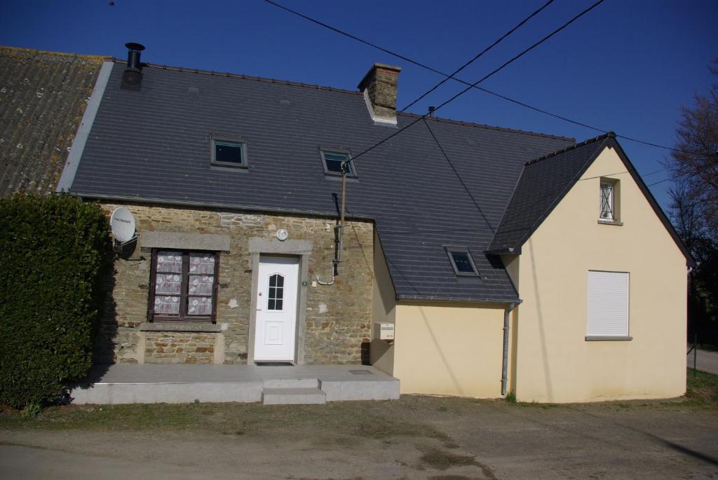 una casa de ladrillo con techo negro en Gîte Caribou en Céaux