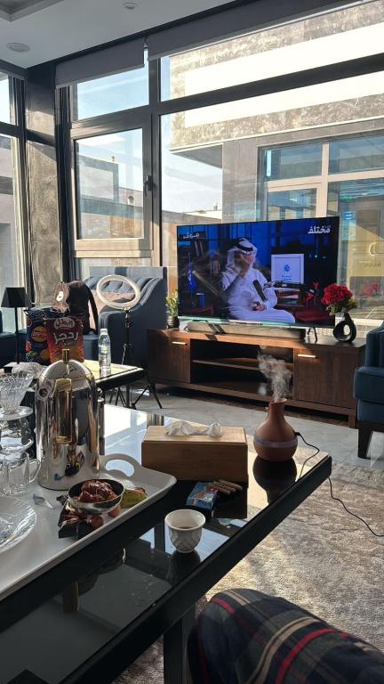 a living room with a table and a tv at شاليه بيسان 2 in Jeddah