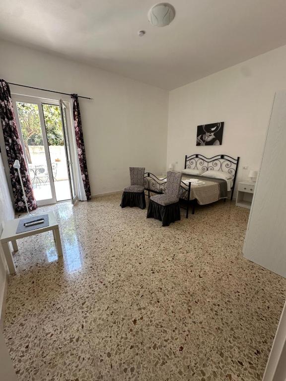 a bedroom with a bed and a table and a window at Residence Prato in Trapani