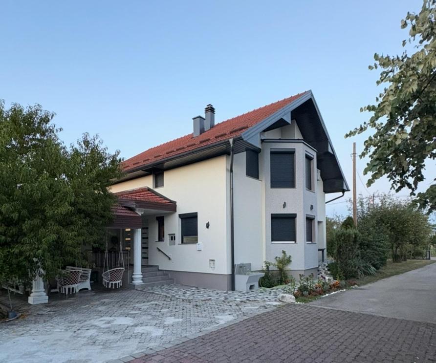 a white house with a red roof at Apartman Lili in Bihać