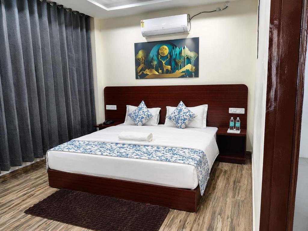 a bedroom with a large bed with blue and white pillows at Kamaksha Palace in Sundarnagar
