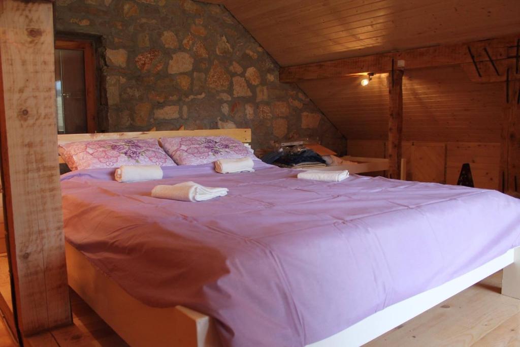 a bedroom with a large purple bed in a room at Mountain house Varda in Ledenice