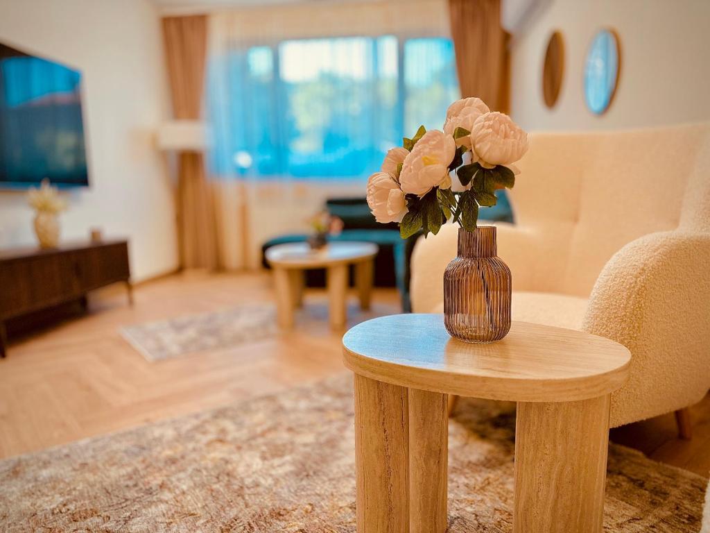 a vase with flowers on a table in a living room at Central Apartment in Kyustendil