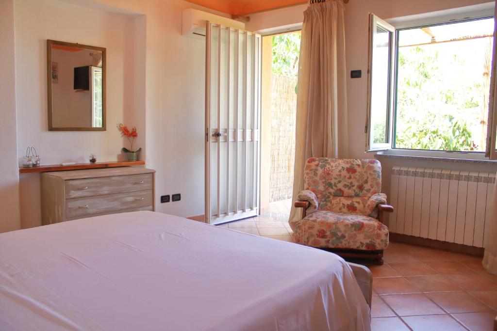 a bedroom with a bed and a chair and a window at Appartamento Mura in Forio d'Ischia