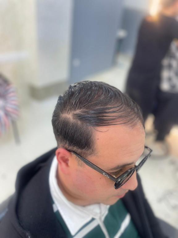 Ein junger Mann mit Brille schaut nach unten in der Unterkunft Riyadh palms in Constantine
