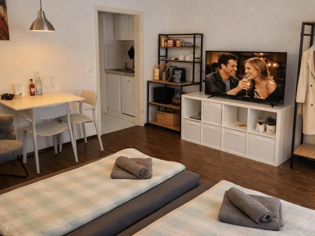 a living room with a flat screen tv and a table at GLORYSTAY - Business Studio-Bosch Campus 2km-Tiefgarage-Workspace-Renningen in Renningen