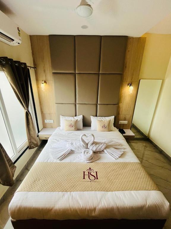a hotel room with a bed with a bow on it at Hotel Shanvi Inn in Jabalpur