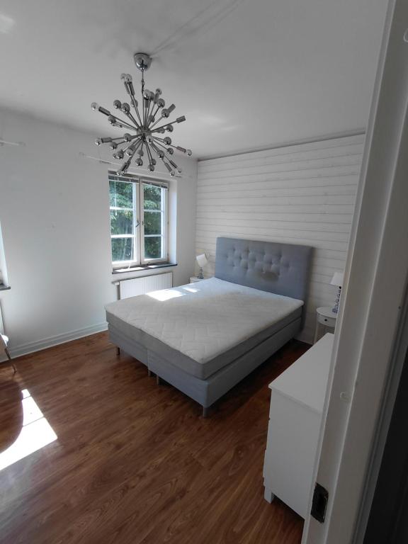 a bedroom with a bed and a chandelier at Old appartment in Helsingborg