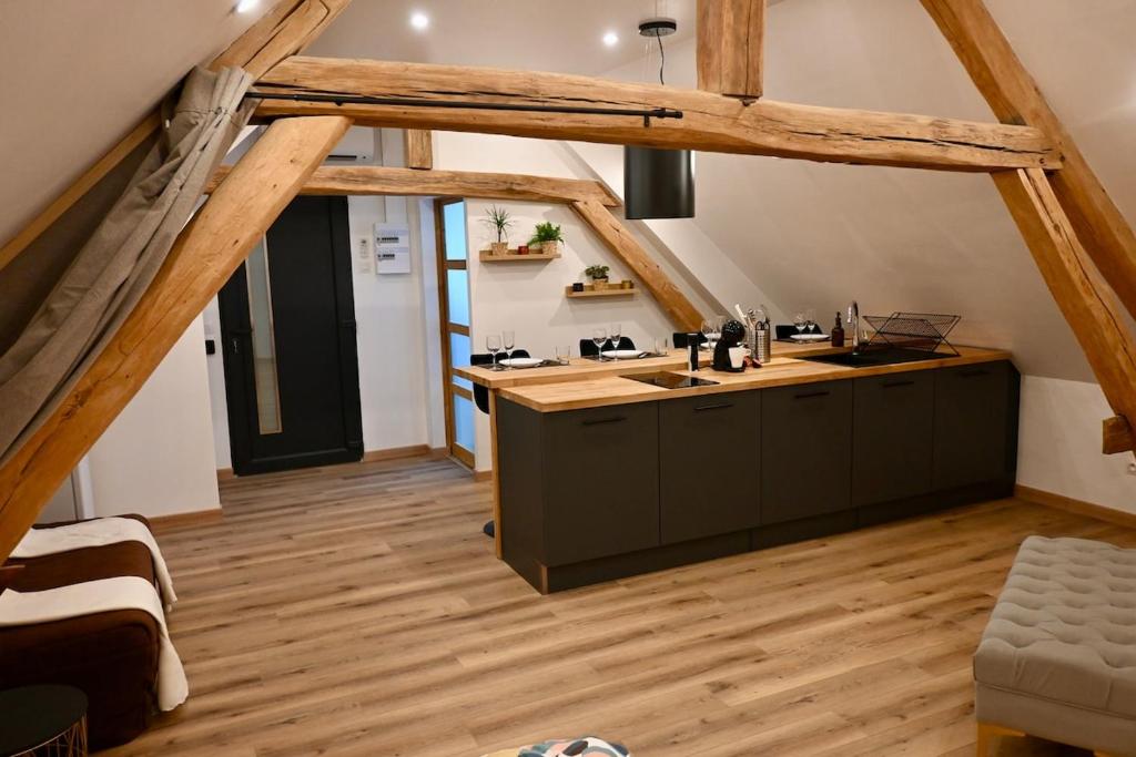 an attic kitchen with wooden floors and a counter top at Superbe Loft proche Troyes & Parking facile in Arcis-sur-Aube