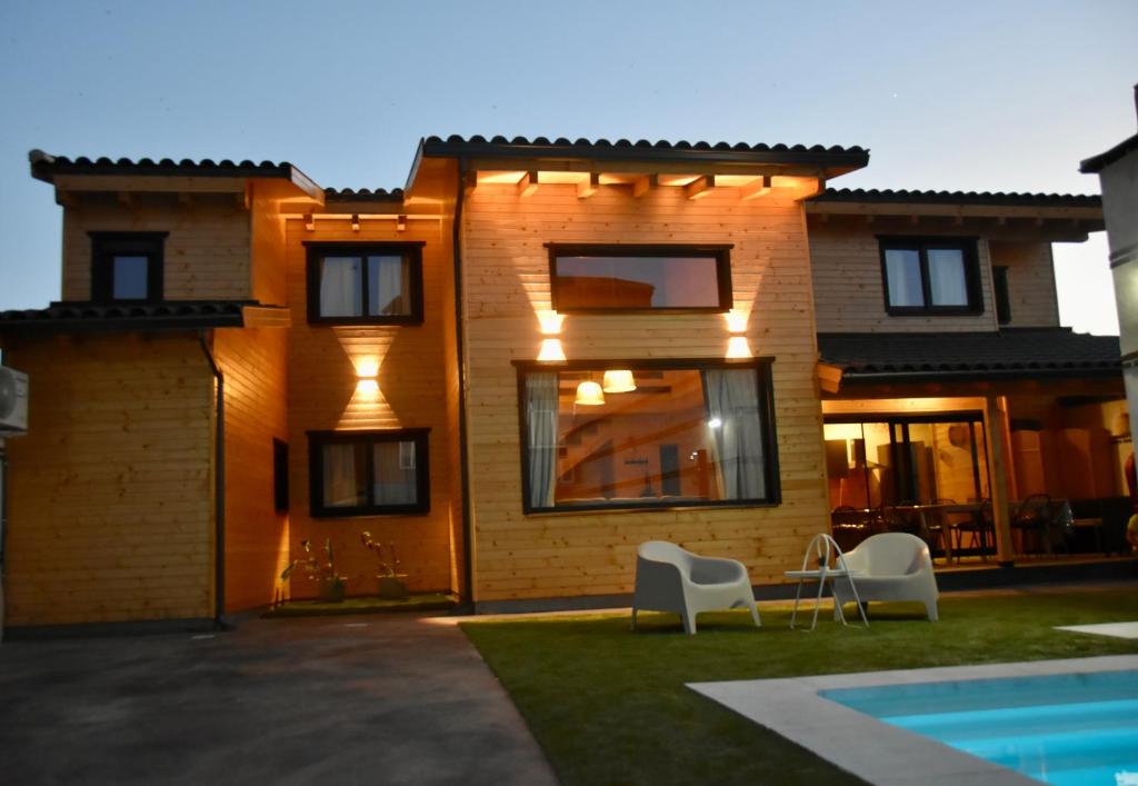 a house with two white chairs in front of it at Casa rural El Pinton in Gálvez