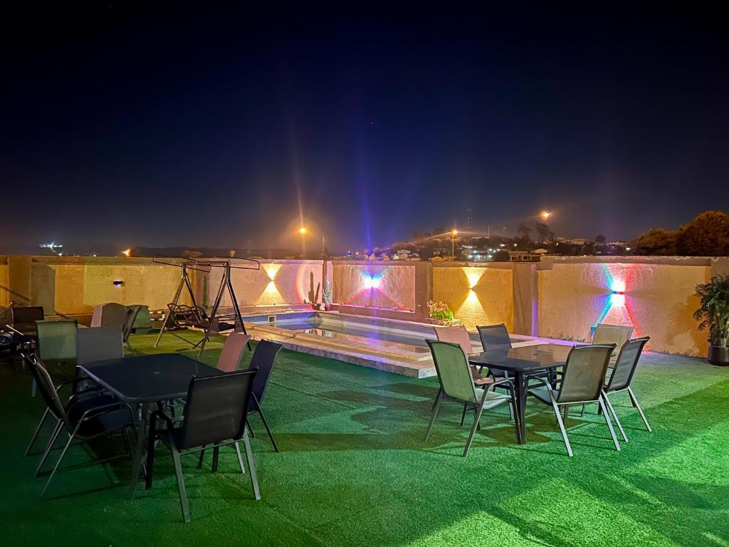 a patio with tables and chairs at night at Piink Lopez in Manzini