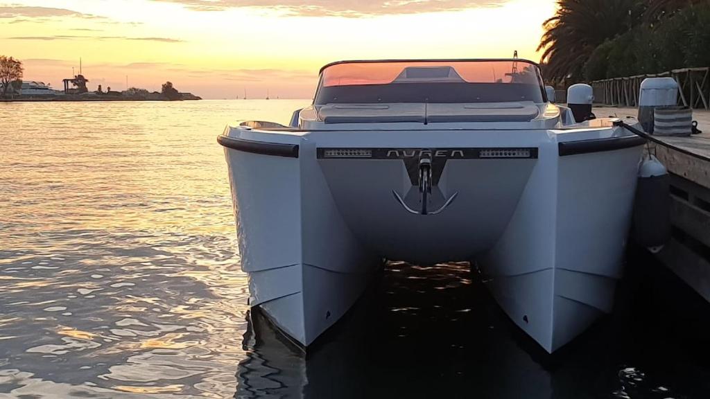 Ein Boot liegt an einem Steg im Wasser. in der Unterkunft Diva Catamarano in Feriolo