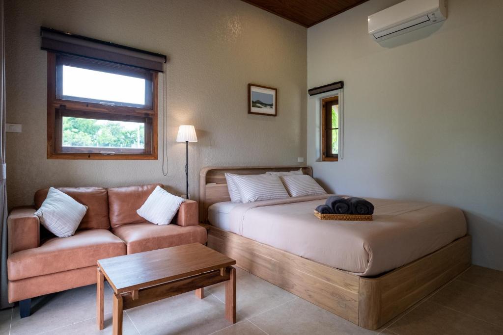 a living room with a bed and a couch at The BROWN PAI in Pai
