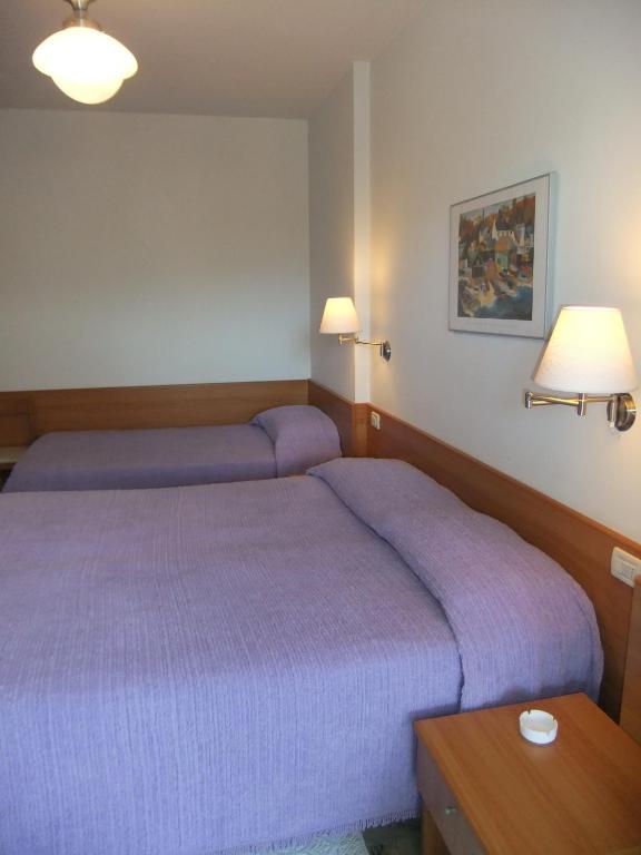 a bedroom with a purple bed and a table at Hotel Giulio Cesare in Cinquale
