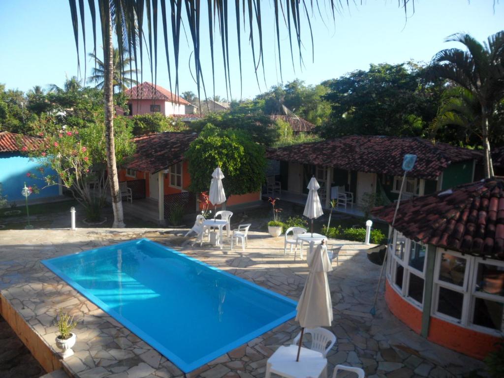 un complejo con piscina y casa en Hotel Pousada Castanheiras do Village, en Porto Seguro