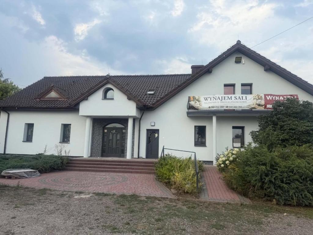 a white building with a sign on it at Hostel in Piotrków Trybunalski