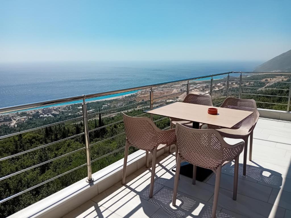 a table and chairs on a balcony with the ocean at Mimi's Apartments, Palasë in Palasë