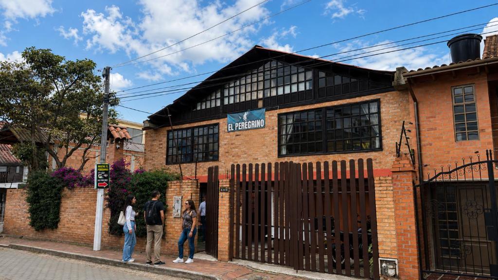 a group of people standing outside of a brick building at El Peregrino in Cota