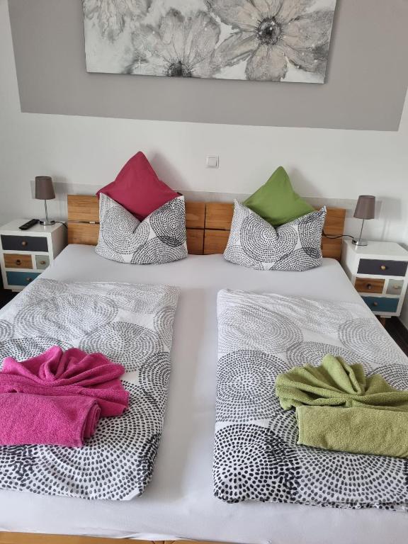 a white bed with two towels sitting on it at Gästehaus Brunnerhof - Eitting in Eitting
