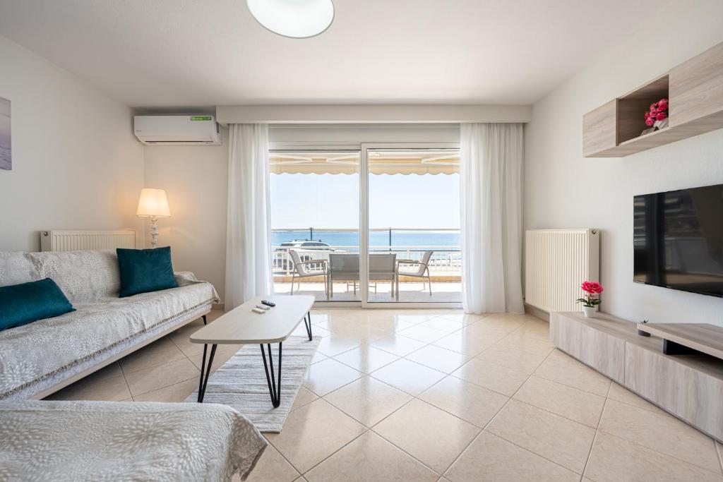 a living room with a couch and a table at Theatre Home Aegean View in Nea Moudania