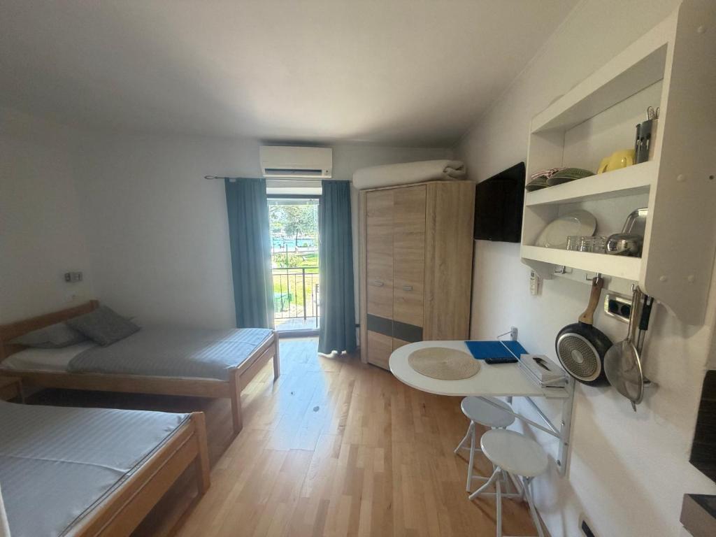 a small room with a bed and a table at Guest House Kvartin in Umag