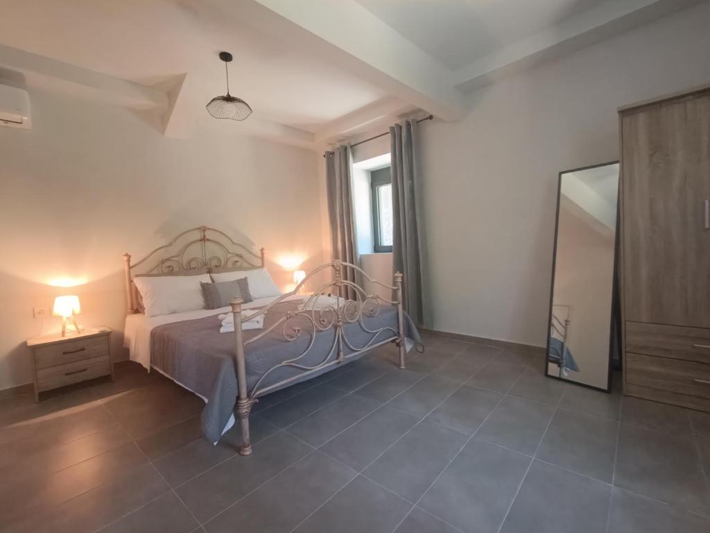 a bedroom with a bed and a dresser and a mirror at River Houses Molyvos in Mythimna