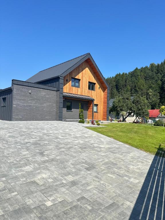 a house with a stone driveway in front of it at Stodoła przy deptaku in Ujsoły