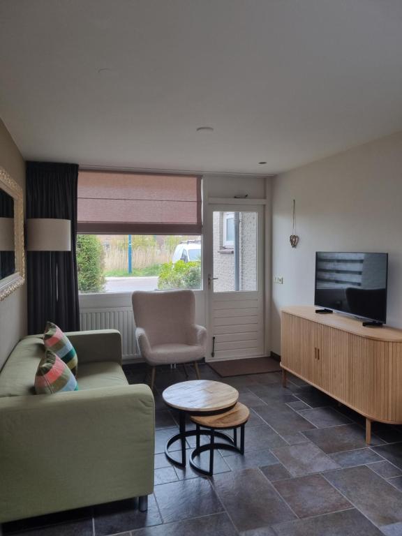a living room with a couch and a tv at Mooi zo 2 in De Koog