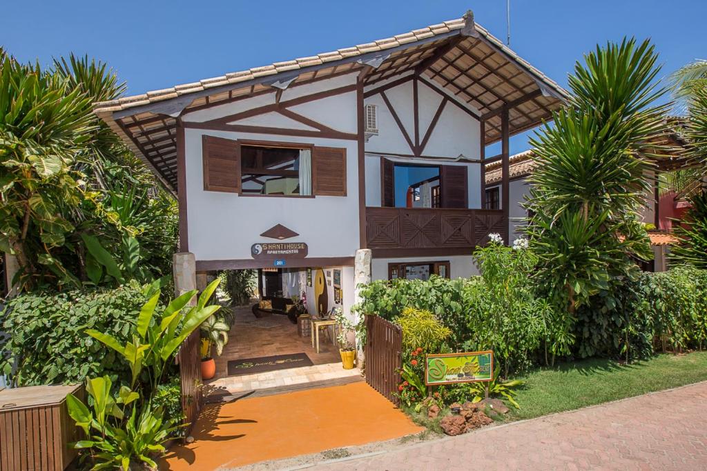 una casa con una puerta delante de ella en Shanti House Apart en Praia do Forte