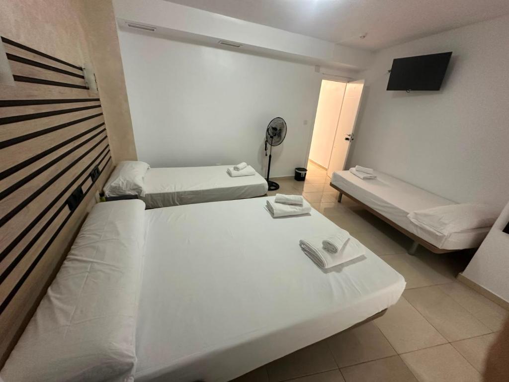a small room with two beds and a television at Hostal Alegria Alicante in Alicante