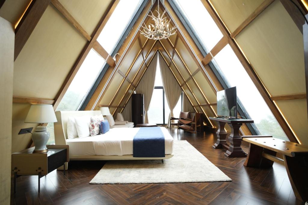 a bedroom with a bed in a room with large windows at Van Rāsa in Kasauli