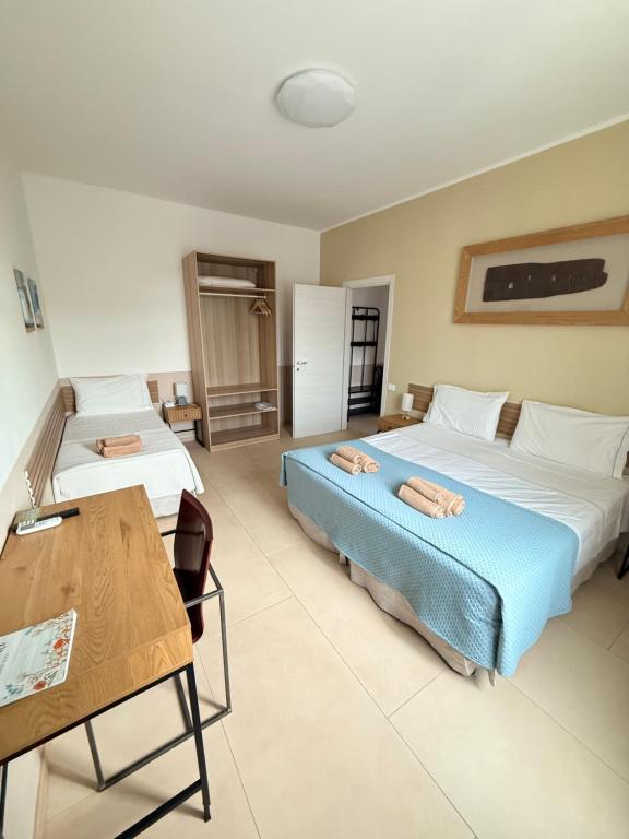 a bedroom with two beds and a table and a desk at Melannie's Apartment 2 in Bergamo