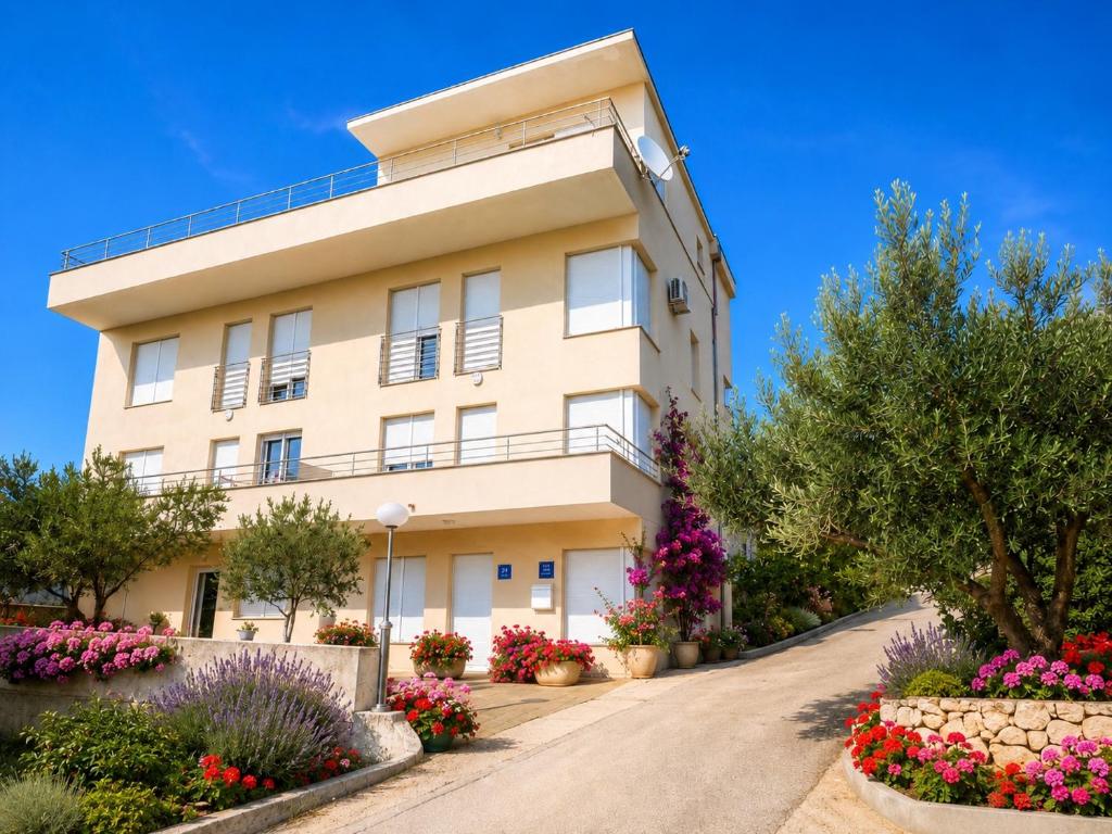a building with flowers in front of it at Villa Jurisic in Tučepi
