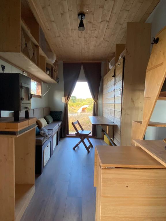 a kitchen with wooden cabinets and a table in a room at Tiny ou Petite maison sur roulettes in Le Fay