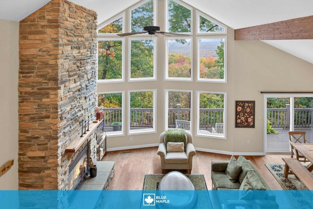 a large living room with a large stone fireplace at Mountain retreat w deck, game room & dog-friendly in Hedgesville