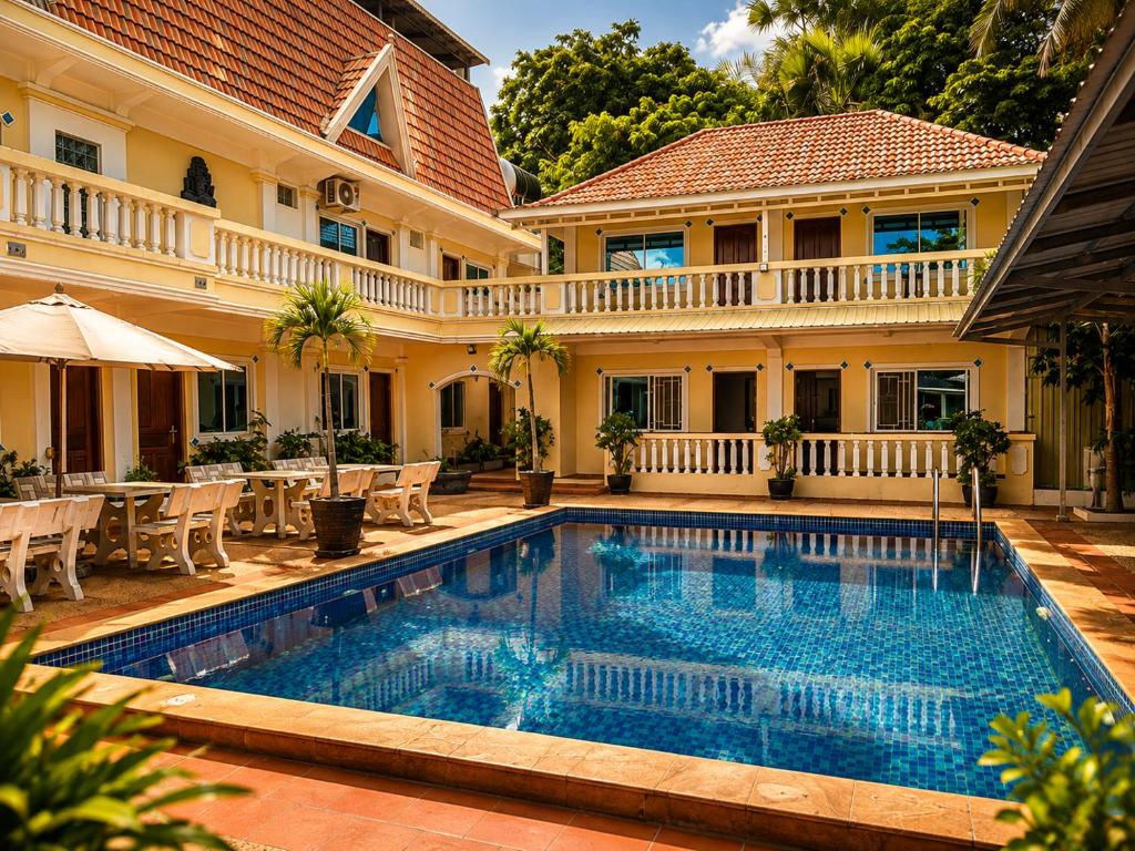 a swimming pool in front of a house at Abode Hotel Siem Reap in Phum Pobos
