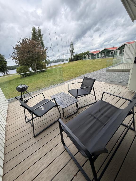 two chairs and a table on a wooden deck at Hindås Lakeside Cabin 4 in Hindås