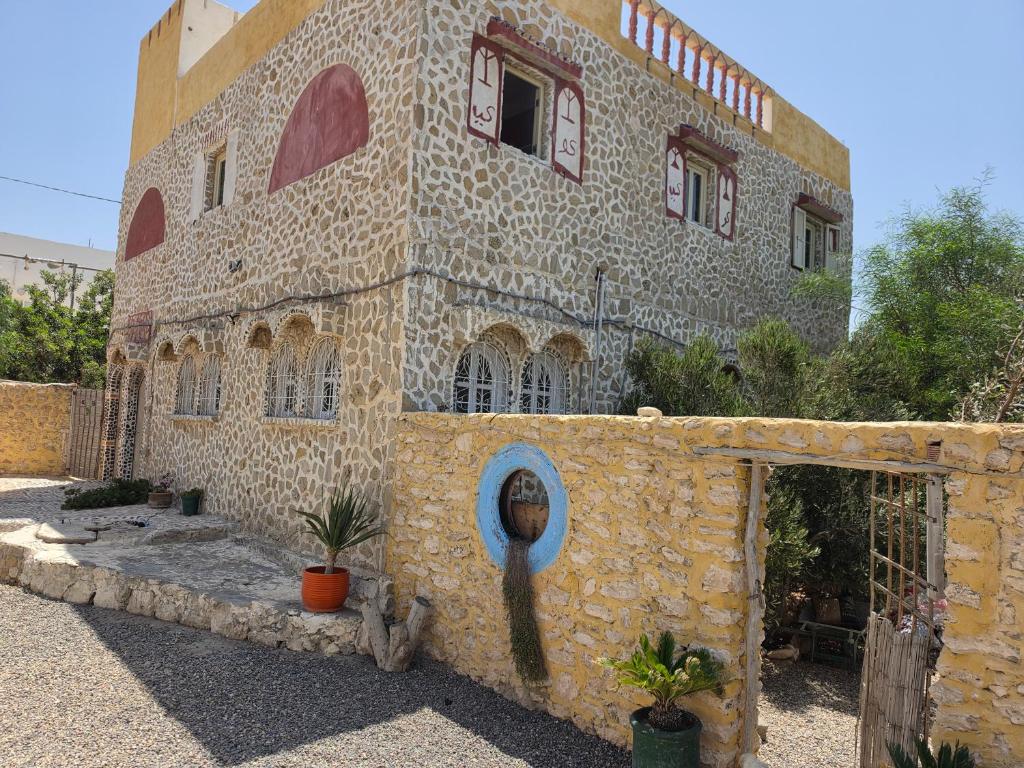 a stone building with a stone wall with a building at Beach House with Sea Views and Rooftop Terrace in Sidi Kaouki