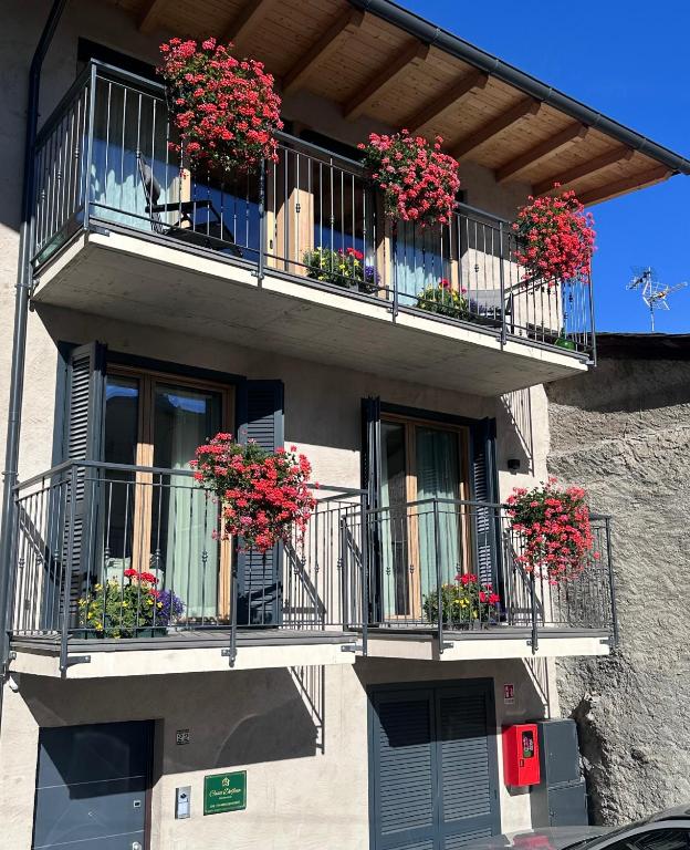 a building with balconies with geraniums on it at Casa Delfina in Grosotto