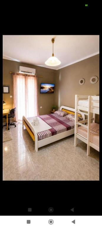 a bedroom with two beds and a desk at Vasiliki apartment in Kalamata