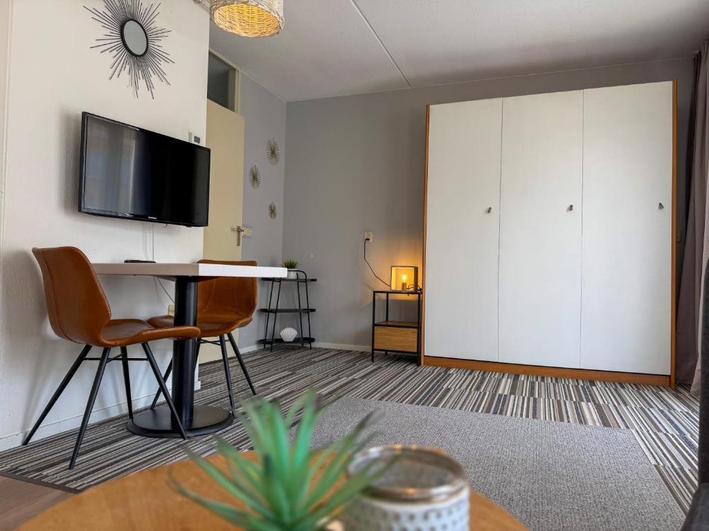a living room with a desk and a tv at Texelheerlijk 10 in De Koog